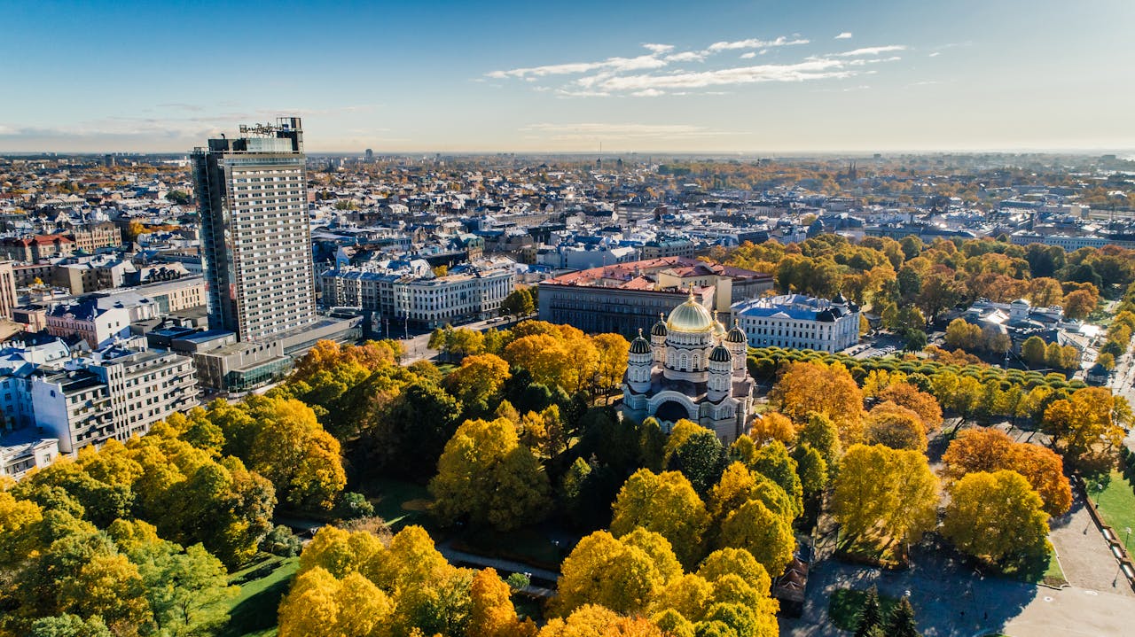 gallery-5 A stunning aerial view of Riga showcasing a cathedral, city architecture, and vibrant fall foliage.