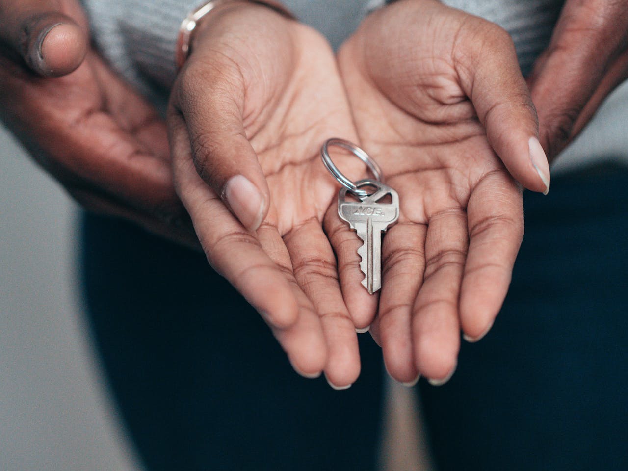 services-01 Close-up of hands holding a key, symbolizing homeownership, real estate, and property investment.